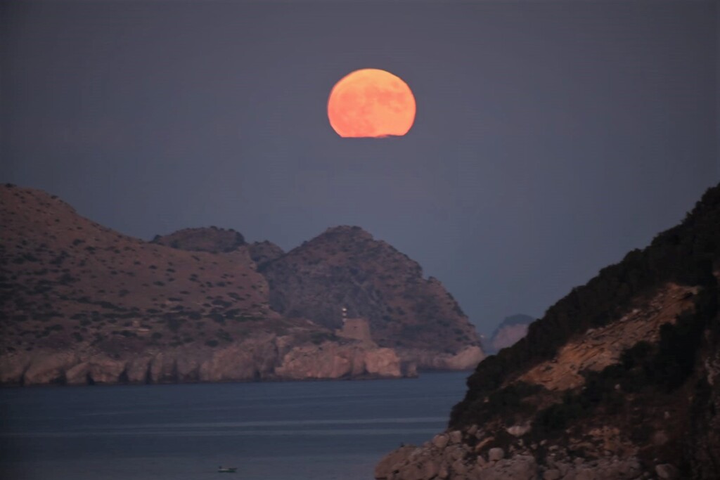 Una rossa luna caprese sorge da dietro Punta Campanella