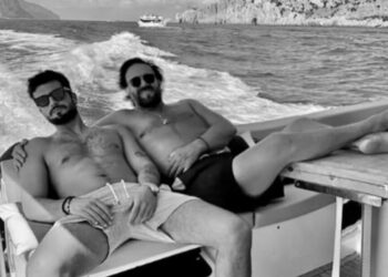 Christian De Sica in barca a Capri, la foto in costume abbracciato a un giovane attore